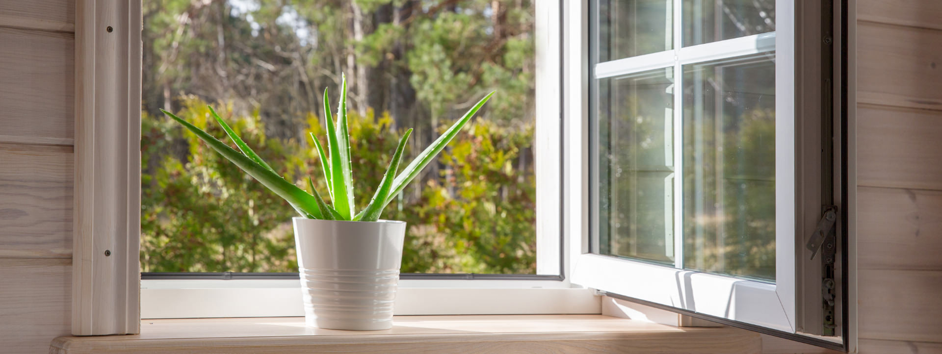 White window in a rustic wooden house overlooking the garden