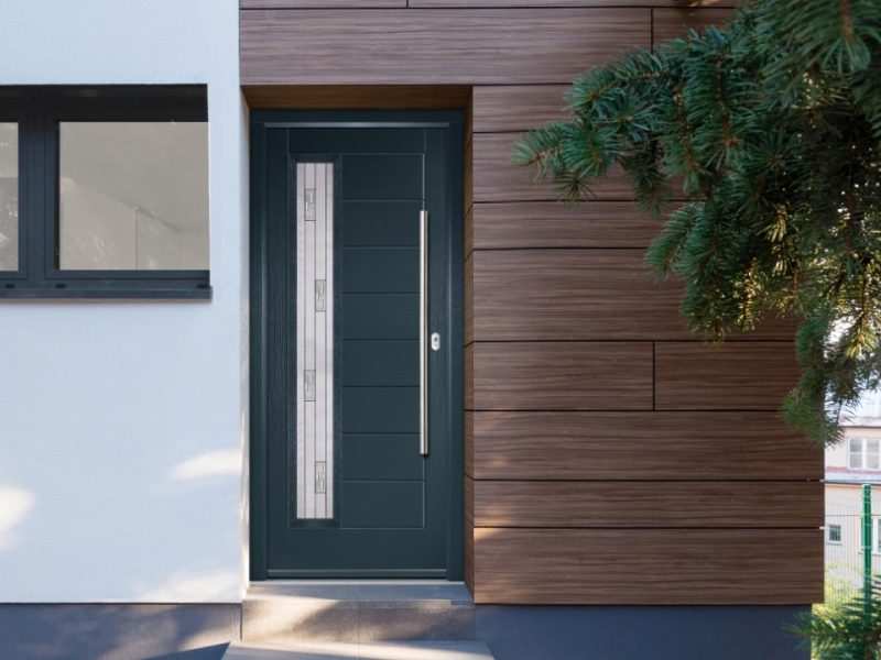 Composite door on modern home with wooden panels
