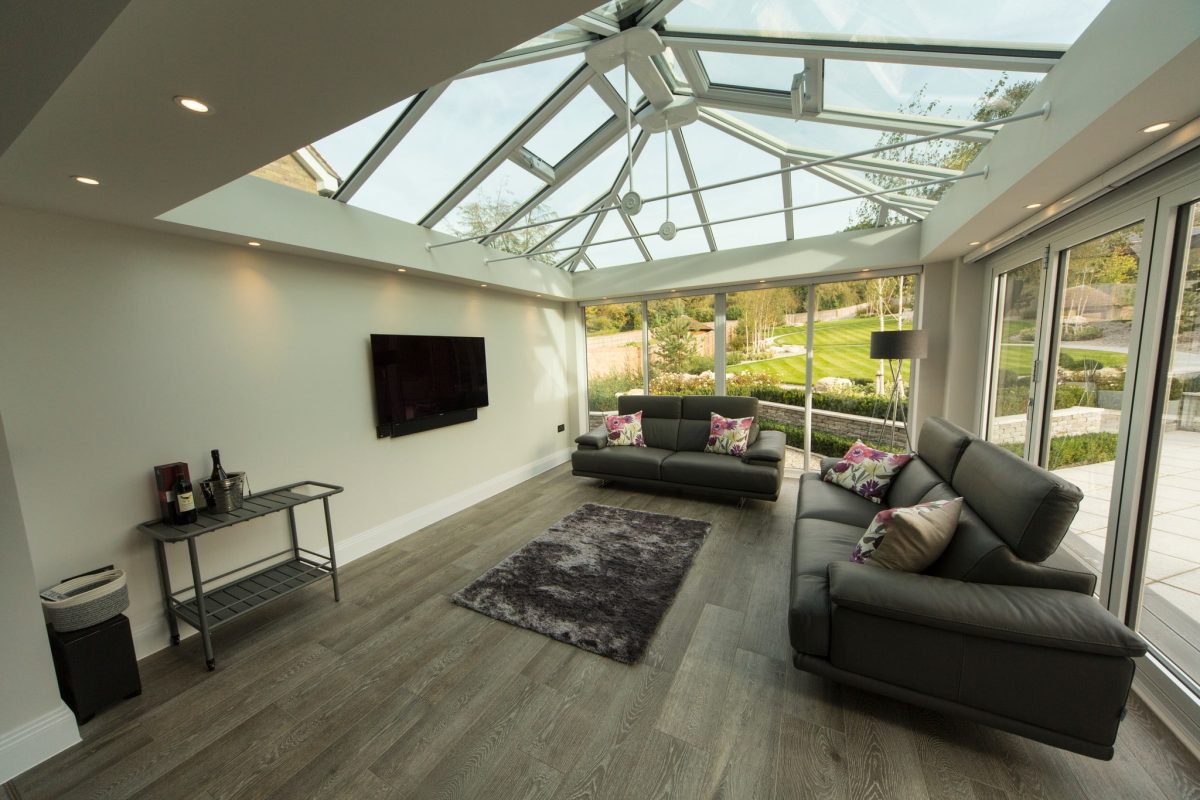 A white T-shaped conservatory interior with a glass roof.