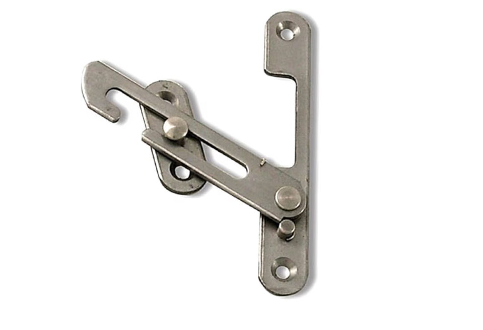 Traditional brass hook and eye window restrictor fitted to a wooden frame for child safety