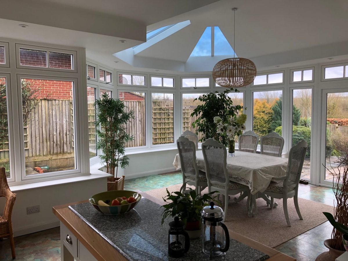 A refurbished conservatory used as a modern open-plan dining space