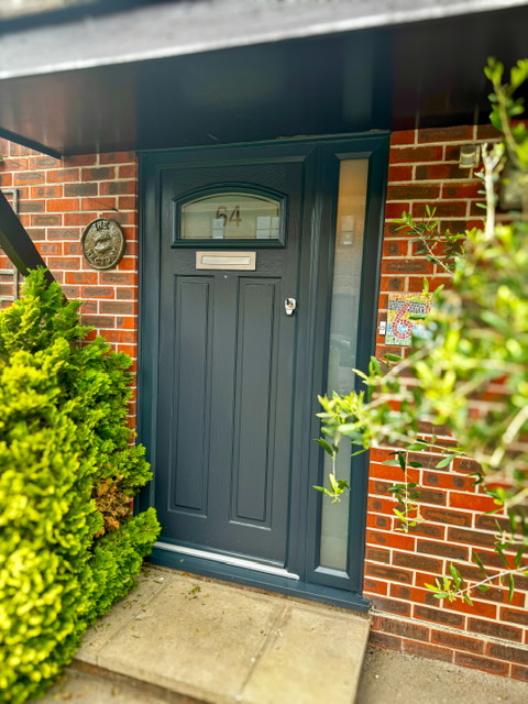 A modern grey composite door with side light