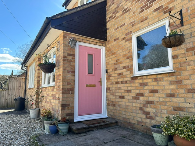 Pink composite front door installed white frame
