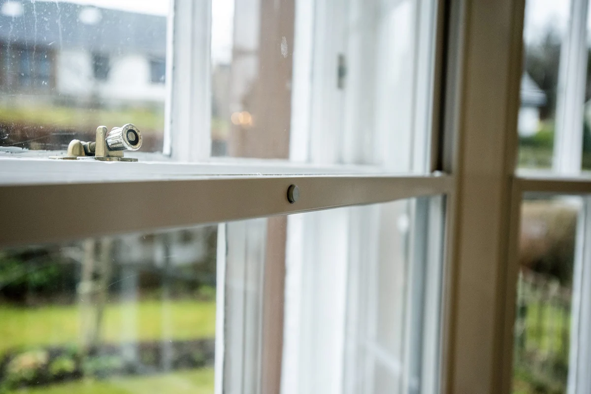 A highly discreet, slim profile aluminium secondary glazing unit professionally installed on a traditional window