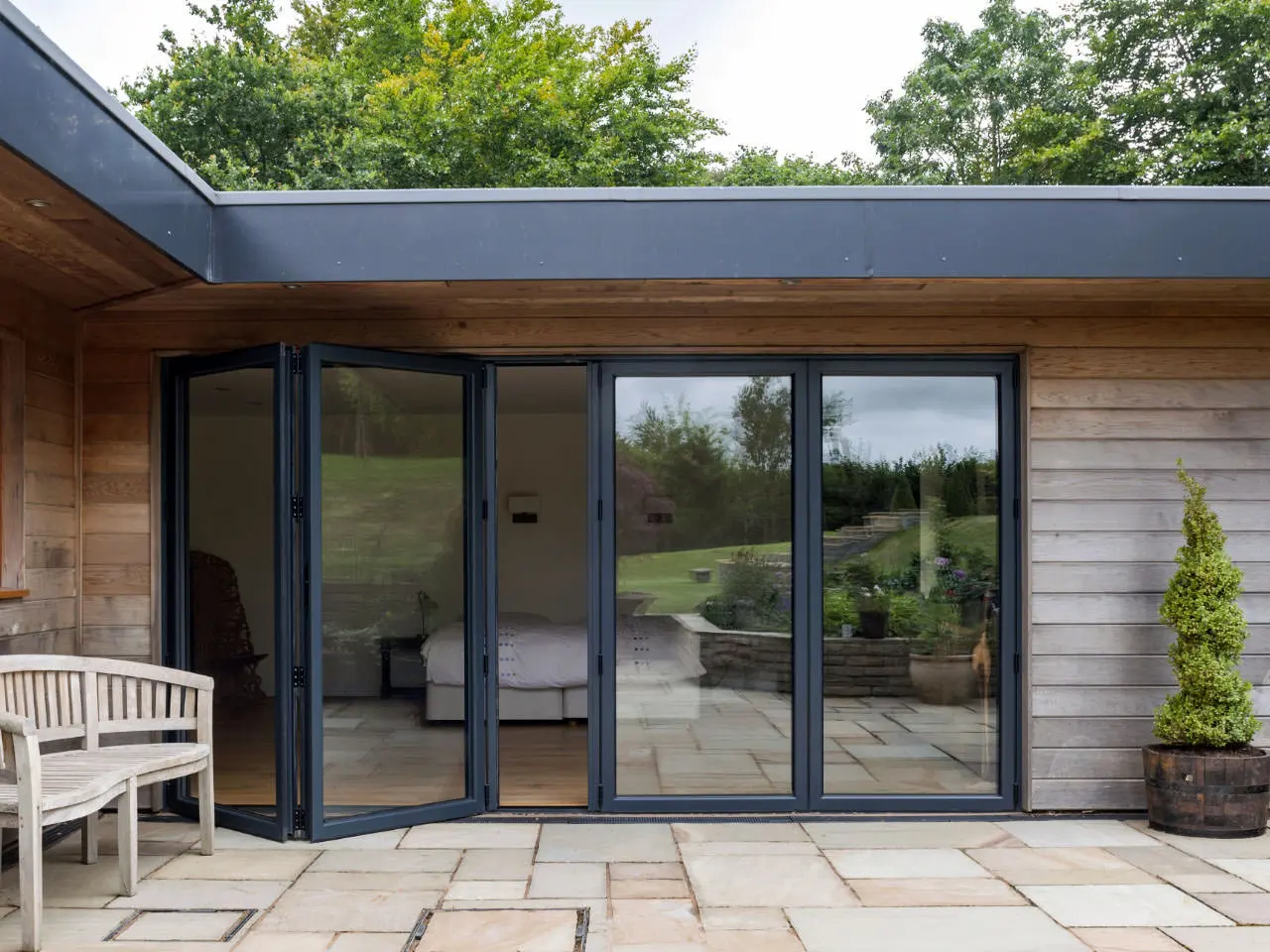 Aluminium bifold doors fully open revealing a garden patio in Hampshire