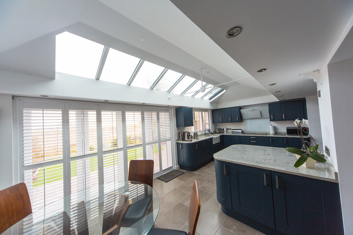 A modern kitchen diner glazed extension with large bi-fold doors letting in sunlight