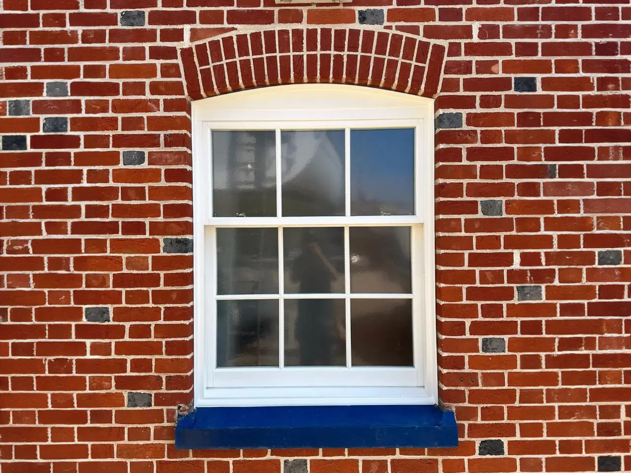 A highly modern white uPVC sliding sash window beautifully demonstrating clean lines and historic proportions
