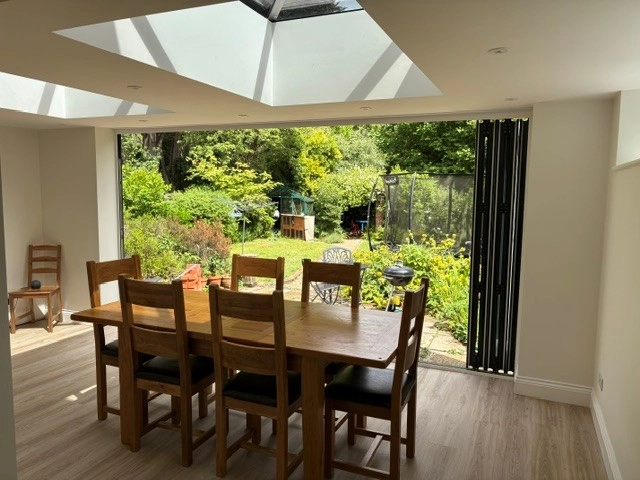 The bright interior view of the new extension showing the roof lanterns and bifold doors