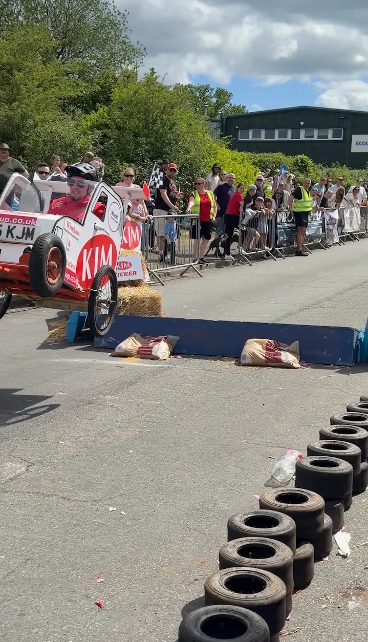 A soapbox kart catching serious air mid-flight after launching off the ramp